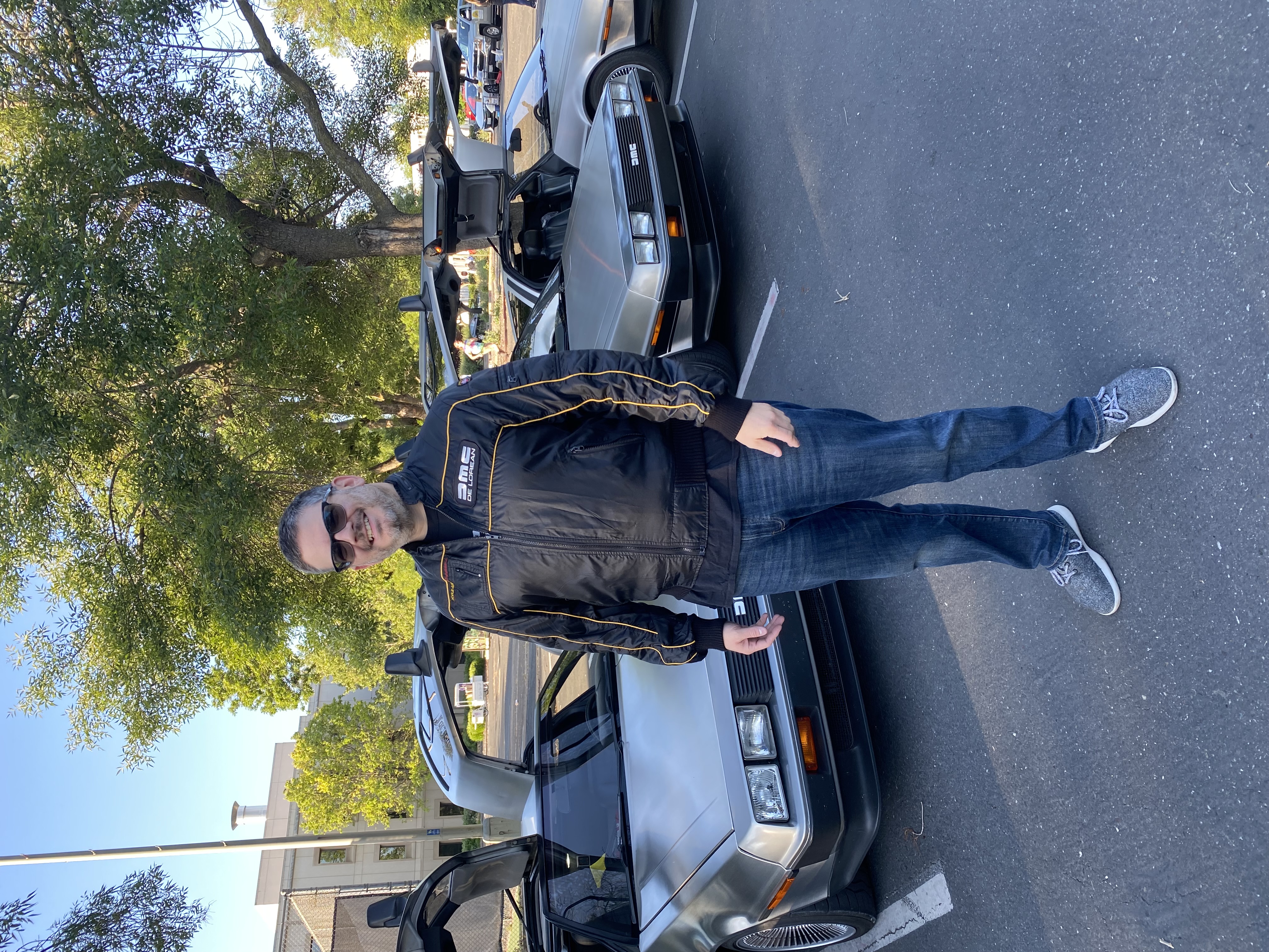 Me in front of the cars with a black logo jacket on